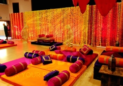 Mendhi Set up with hanging thoron backdrop and gold seating